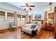Inviting bedroom boasts a woven headboard, wood floors, ceiling fan, and windows with stylish roman shades at 2326 2Nd E Ave, Bradenton, FL 34208