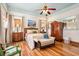 Charming bedroom features a ceiling fan, ample windows, wooden floors and a decorative wardrobe and bench at 2326 2Nd E Ave, Bradenton, FL 34208