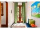 Bright entryway features double doors with green curtains and a comfortable blue bench with colorful pillows at 2326 2Nd E Ave, Bradenton, FL 34208