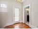 Hallway with hardwood floors leads to a door with sheer curtains and a doorway to a powder room at 2326 2Nd E Ave, Bradenton, FL 34208