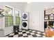 Laundry room with checkered tile floor, stacked washer/dryer, and two windows at 2326 2Nd E Ave, Bradenton, FL 34208