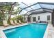 Relaxing outdoor pool area featuring lounge chairs, a screened enclosure, and blue accent tiling at 2326 2Nd E Ave, Bradenton, FL 34208