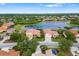 Aerial view of a single-Gathering home situated on a tree-lined street near a serene lake and lush surroundings at 244 Dove Trl, Bradenton, FL 34212