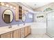 Bright bathroom with double sinks, soaking tub, walk-in shower, and decorative wallpaper at 244 Dove Trl, Bradenton, FL 34212