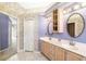 Bathroom with double sink vanity, oval mirrors, floral wallpaper, and view of hallway at 244 Dove Trl, Bradenton, FL 34212