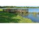 Scenic view of a wooden dock extending into a tranquil lake, perfect for enjoying nature and waterfront activities at 244 Dove Trl, Bradenton, FL 34212