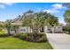 Front exterior of a single-story home featuring a lush front yard, mature trees, and a spacious driveway at 244 Dove Trl, Bradenton, FL 34212