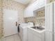 Well-lit laundry room features a washer, dryer, and a practical sink with storage at 244 Dove Trl, Bradenton, FL 34212