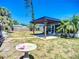 Backyard featuring a gazebo, screened-in porch, bird bath, and lawn at 2705 21St W Ave, Bradenton, FL 34205