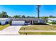 Charming single-story home featuring a red front door, well-manicured lawn, and an attached one car garage at 2705 21St W Ave, Bradenton, FL 34205