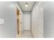 Hallway with many storage closets leading to bathroom featuring modern tile flooring and neutral gray walls at 3119 40Th W Ave, Bradenton, FL 34205
