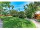 Lush backyard featuring manicured lawns, mature trees, and privacy landscaping at 412 73Rd St, Holmes Beach, FL 34217