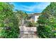 Exterior backyard view of home with lush landscaping, stone walk and a deck at 412 73Rd St, Holmes Beach, FL 34217