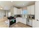 Modern kitchen with white cabinets, stainless steel appliances, and granite countertops at 412 73Rd St, Holmes Beach, FL 34217