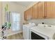 Well-equipped laundry room with wooden cabinets, washer, and dryer for convenient laundry care at 412 73Rd St, Holmes Beach, FL 34217