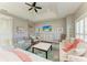 Well-lit living room has tray ceilings, fan, wood flooring and comfortable furniture at 412 73Rd St, Holmes Beach, FL 34217