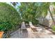 Outdoor lounge area features two chairs with a table, nestled amongst tropical foliage at 412 73Rd St, Holmes Beach, FL 34217