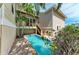 Backyard view of a home with pool and a patio area, surrounded by vibrant tropical foliage at 412 73Rd St, Holmes Beach, FL 34217