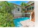 Backyard pool with brick pavers, tropical landscaping, and stairs to the second story deck at 412 73Rd St, Holmes Beach, FL 34217