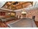 Recreational billiard room featuring exposed brick, wood paneling and a coffered ceiling at 4350 Chatham Dr # E-105, Longboat Key, FL 34228