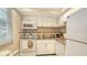 Bright kitchen with white appliances, granite countertops, and mosaic backsplash at 4350 Chatham Dr # E-105, Longboat Key, FL 34228