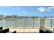 Wide balcony with glass railings overlooking beautiful water and city views; perfect for outdoor relaxation at 464 Golden Gate Pt # 702, Sarasota, FL 34236