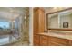 Beautiful bathroom featuring a glass-enclosed shower, custom cabinetry, and marble countertop at 464 Golden Gate Pt # 702, Sarasota, FL 34236