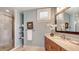 Modern bathroom with a glass-enclosed shower, floating shelves, and a wooden vanity with marble countertop at 464 Golden Gate Pt # 702, Sarasota, FL 34236