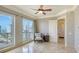 Bright bedroom featuring a ceiling fan, neutral walls, and large windows with city views at 464 Golden Gate Pt # 702, Sarasota, FL 34236