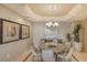 Formal dining room featuring a round table, modern chandelier, and elegant decor at 464 Golden Gate Pt # 702, Sarasota, FL 34236