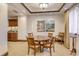 Cozy dining area featuring a round table, upholstered chairs, artwork, and a built-in bar at 464 Golden Gate Pt # 702, Sarasota, FL 34236
