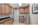 Well-equipped laundry room features sleek cabinetry, granite countertops, modern appliances, and tiled floors at 464 Golden Gate Pt # 702, Sarasota, FL 34236