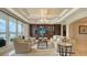 Elegant living room with coffered ceilings, custom built-ins, and water views from sliding glass doors at 464 Golden Gate Pt # 702, Sarasota, FL 34236
