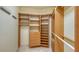 Walk-in closet featuring custom wood shelving, drawers and plenty of space for organization at 464 Golden Gate Pt # 702, Sarasota, FL 34236