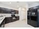 Kitchen with dark cabinets, appliances, and white countertops complemented by an adjacent pantry at 4781 Vignette Way, Sarasota, FL 34240