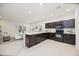 Modern kitchen with dark cabinets, stainless steel appliances, and granite countertops in an open floor plan at 4781 Vignette Way, Sarasota, FL 34240