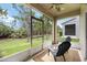 Relaxing screened patio featuring chairs and a ceiling fan, overlooking the lawn at 4781 Vignette Way, Sarasota, FL 34240