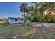 View of the side and backyard with trees and grass at 4823 Linwood St, Sarasota, FL 34232
