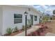 Detailed front of a single-story white home, highlighting updated lighting and fresh, attractive landscaping at 4823 Linwood St, Sarasota, FL 34232