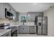 Modern kitchen featuring sleek gray cabinets, stainless steel appliances, and elegant countertop at 4823 Linwood St, Sarasota, FL 34232
