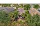 Aerial view of a tile roof home in a tropical neighborhood with lush landscaping and mature trees at 5009 Lake Overlook Ave, Bradenton, FL 34208