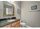 Bathroom featuring granite countertops, framed mirror, tile flooring, toilet, and wall decor at 5009 Lake Overlook Ave, Bradenton, FL 34208