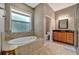Bathroom with a tiled bathtub and granite countertop vanity with view to the toilet and shower at 5009 Lake Overlook Ave, Bradenton, FL 34208