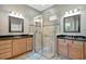 Bathroom with a glass shower, granite countertops, tiled floor, and dual sinks with vanity lighting at 5009 Lake Overlook Ave, Bradenton, FL 34208