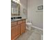 Bathroom with granite countertops, wood vanity, toilet, tile floor, and decorative mirror at 5009 Lake Overlook Ave, Bradenton, FL 34208
