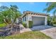 Single Gathering home with well-manicured landscaping, lush trees, and a brick-paved driveway at 5009 Lake Overlook Ave, Bradenton, FL 34208