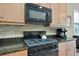 Up-close picture of kitchen features a cooktop, microwave, and granite countertops at 5009 Lake Overlook Ave, Bradenton, FL 34208