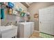 Practical laundry room equipped with white washer and dryer, sink, storage, and plenty of shelving at 5009 Lake Overlook Ave, Bradenton, FL 34208