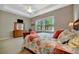 Comfortable main bedroom with a large window showing a lush landscape view and a tray ceiling with fan at 5009 Lake Overlook Ave, Bradenton, FL 34208