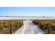 Scenic sandy path leads to the pristine beach with lifeguard towers, offering a tranquil and inviting atmosphere at 5134 Northridge Rd # 106, Sarasota, FL 34238